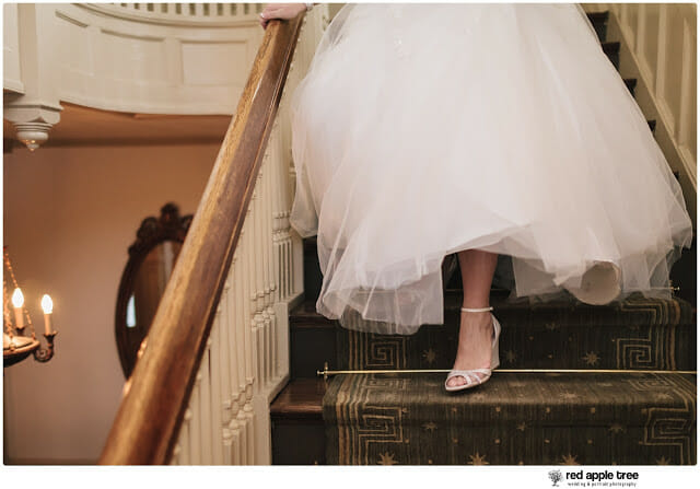 Bride walking down staircase in wedding dress